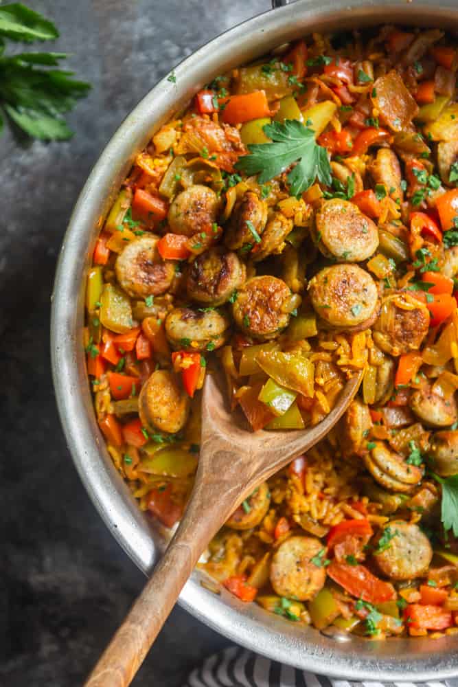 sauasge, peppers and rice skillet with serving spoon