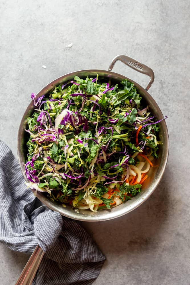 frying pan with grated carrots and green mix