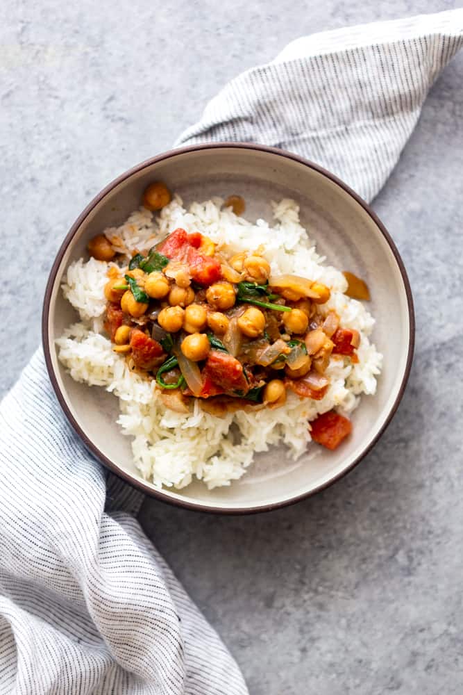 Coconut chickpea curry in a bowl with a blue and white striped napkin