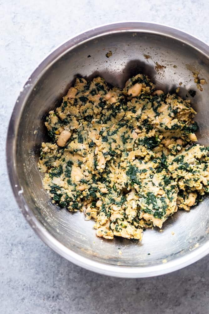 white bean and kale mixture in a silver bowl