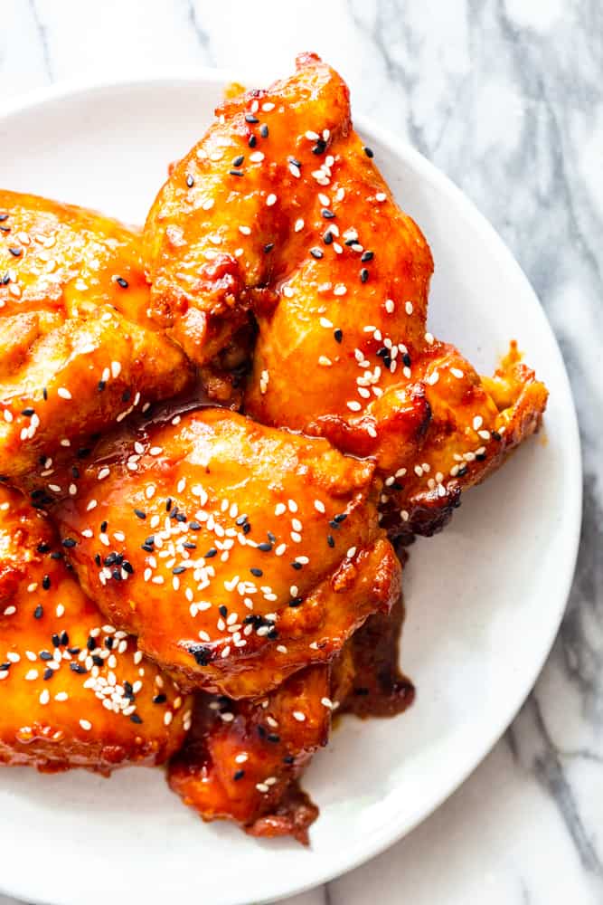 Sticky Korean Chicken Thighs on a white plate closeup