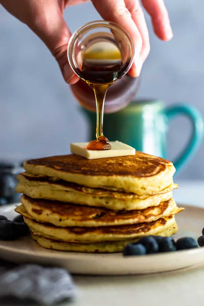 Maple Syrup pouring onto a stack of pancakes