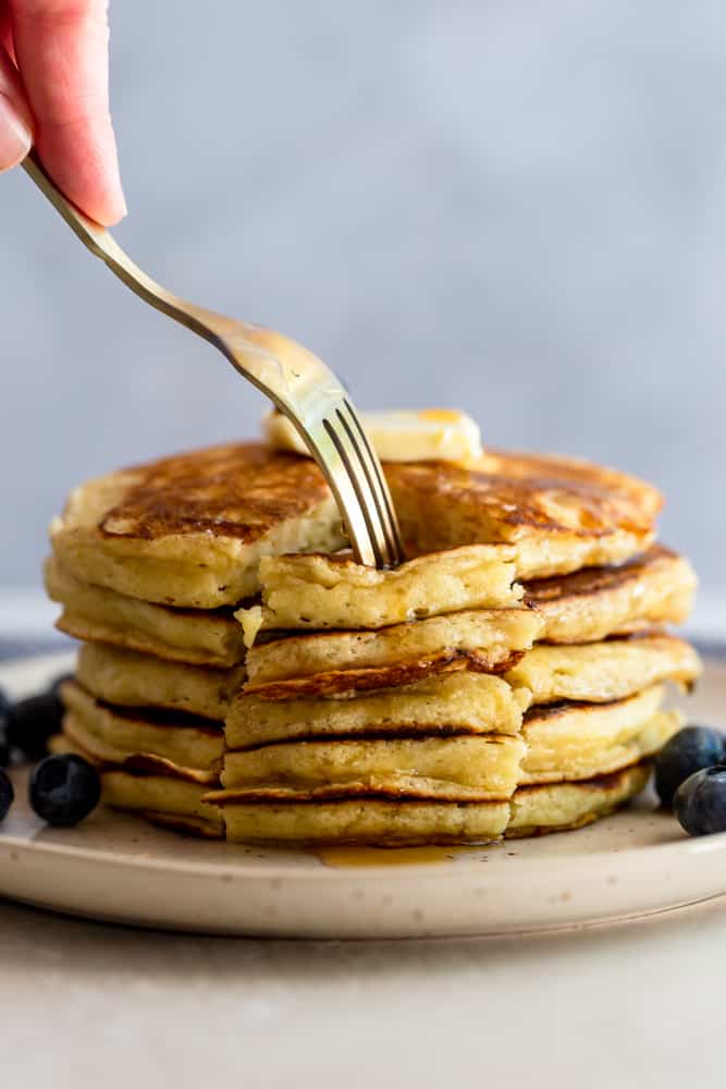 A fork pressing into a wedge of pancakes