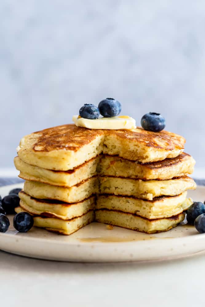 A stack of pancakes with a wedge cut out