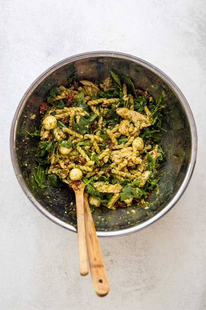 Chicken Pesto Pasta Salad mixed in a large stainless steel bowl