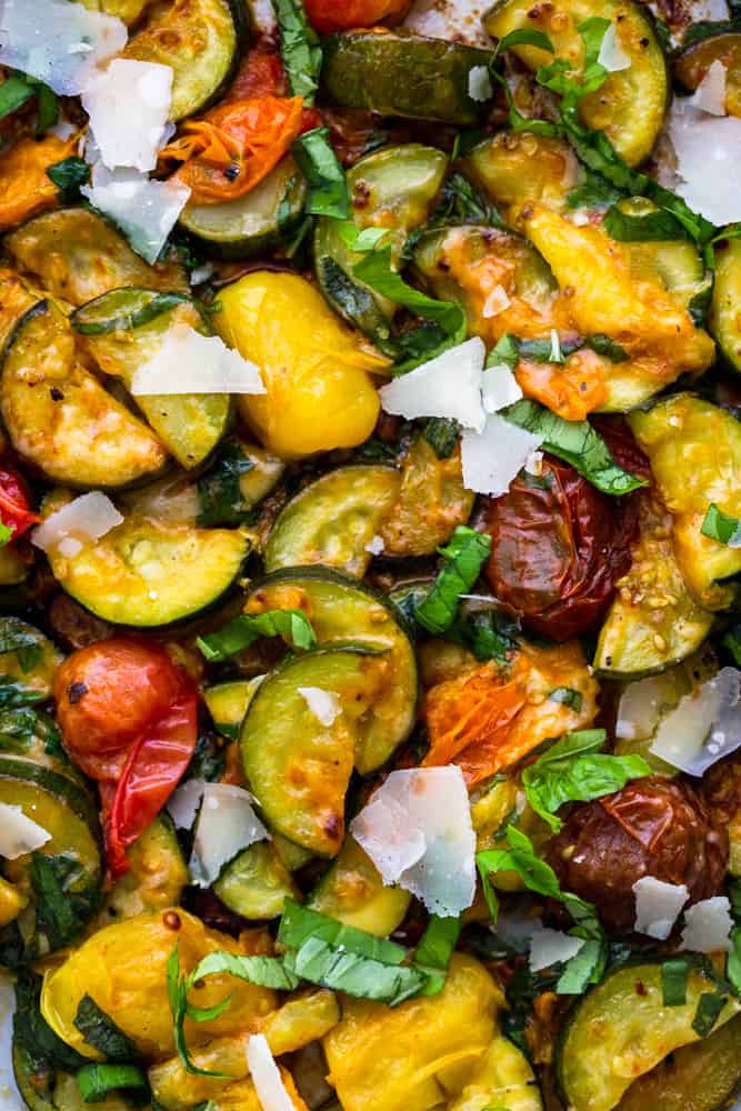 Close up of sauteed zucchini and cherry tomatoes with basil and Parmesan cheese