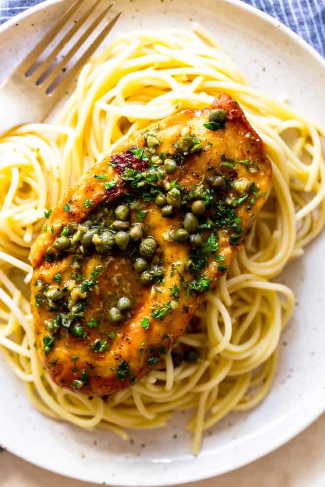 one serving of chicken piccata with capers on a bed of noodles