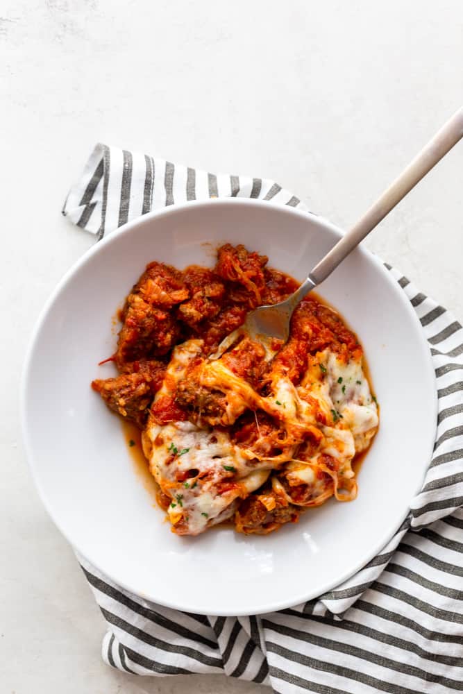 Spaghetti Squash Casserole in a white bowl on a black and white striped towel