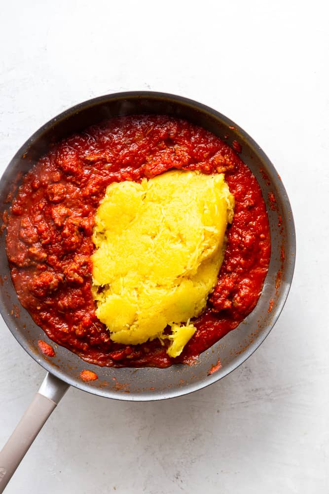 Spaghetti sauce with sausage and cooked spaghetti squash in a pan