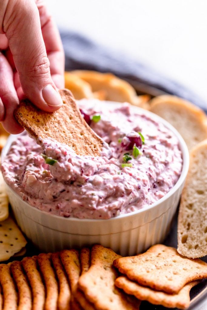 Cracker dipping into cranberry dip