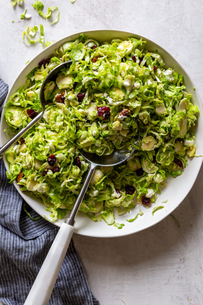 Shaved brussels sprouts salad in a white bowl