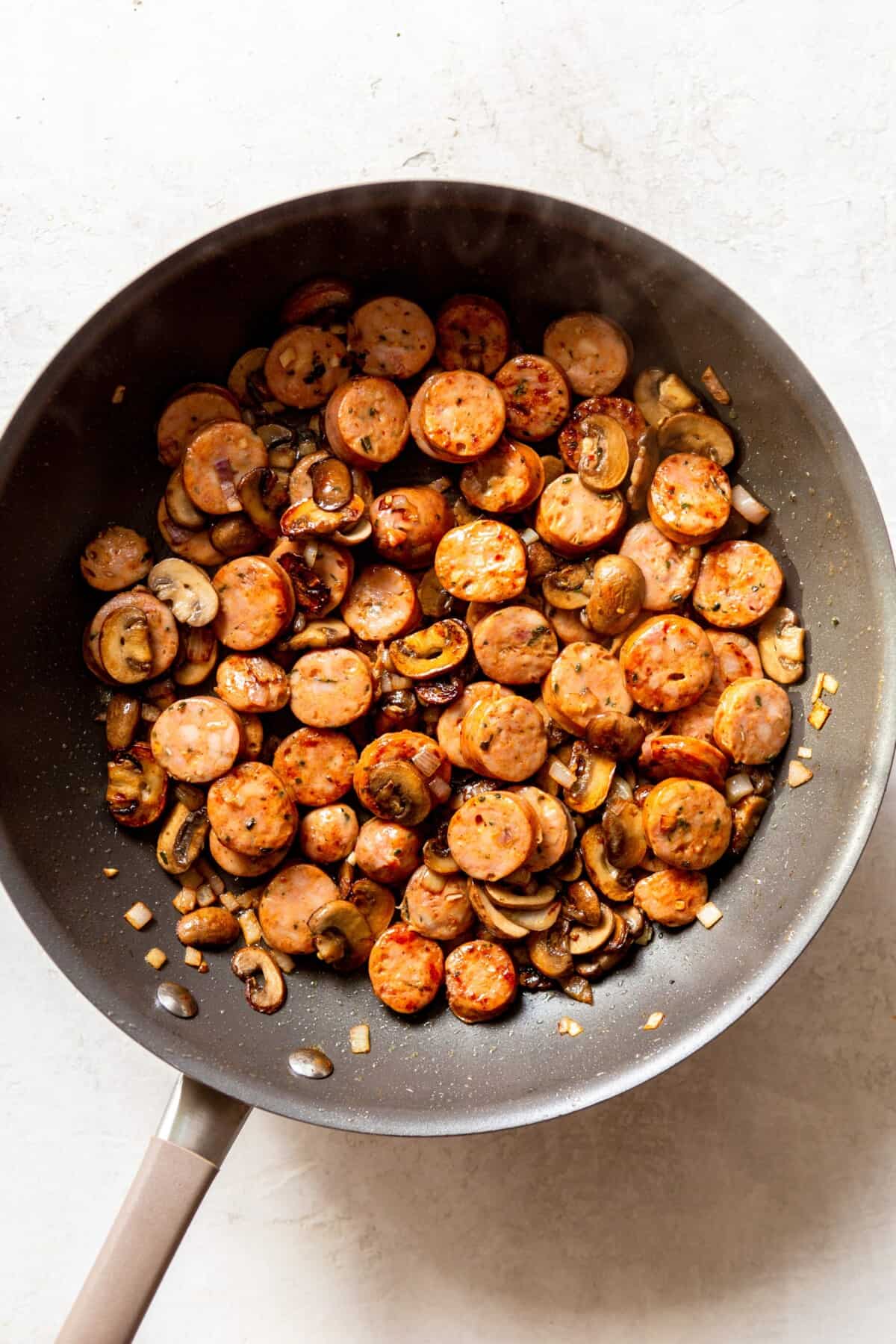 sausage and mushrooms in a frying pan