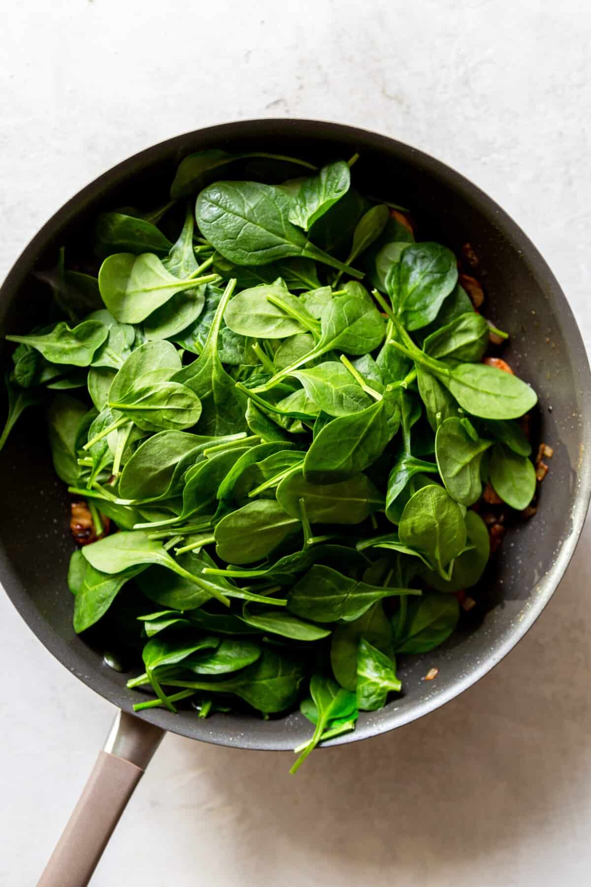 Raw spinach after being added to the pan