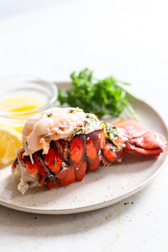 Cooked lobster tail on a white plate