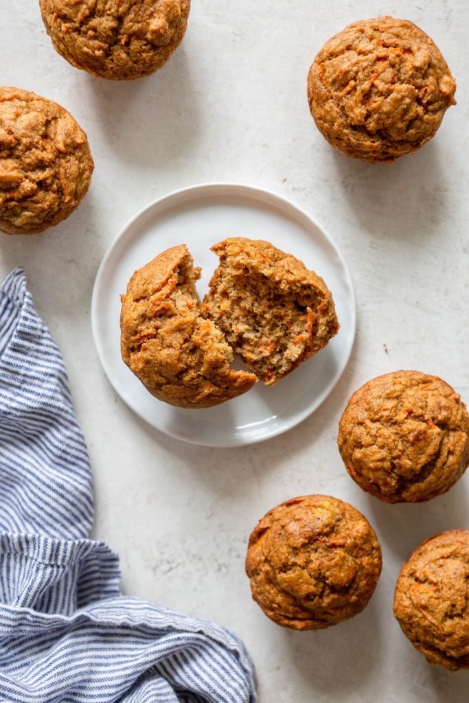 Carrot Banana Muffin on a white plate, more muffins around it. 