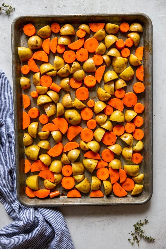 potatoes and carrots on a sheet pan before roasting.