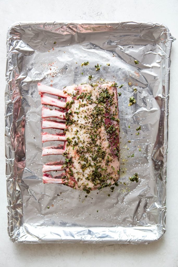 Rack of lamb rubbed with herb mixture before cooking.