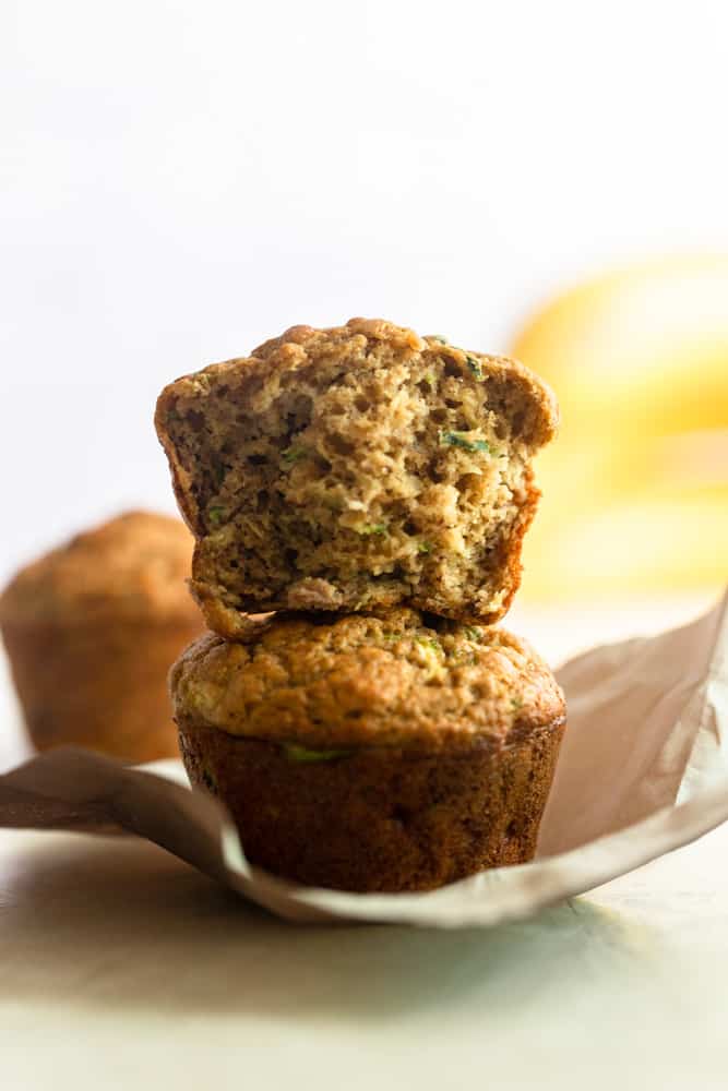 Two banana zucchini muffins stacked on top of each other 