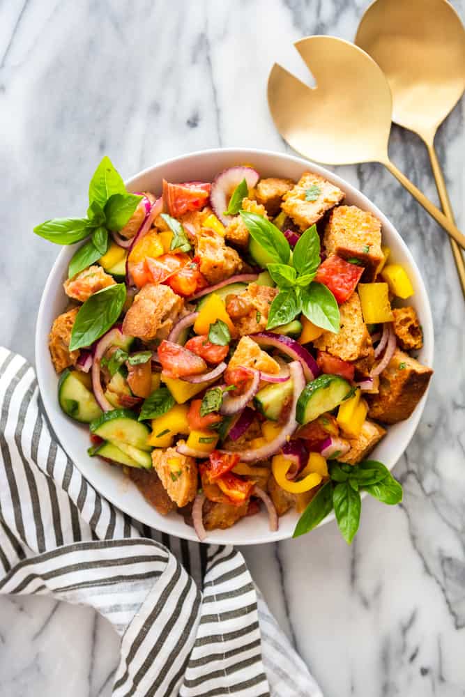 Panzanella bread salad in a white bowl on a marble counter