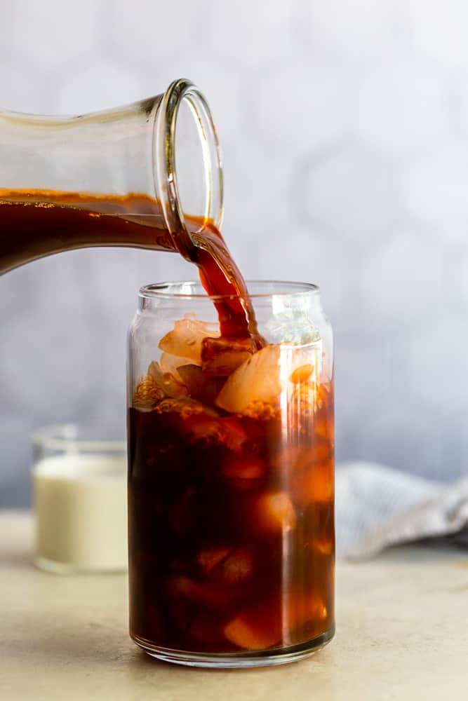 Thai Tea pouring into a glass with ice.