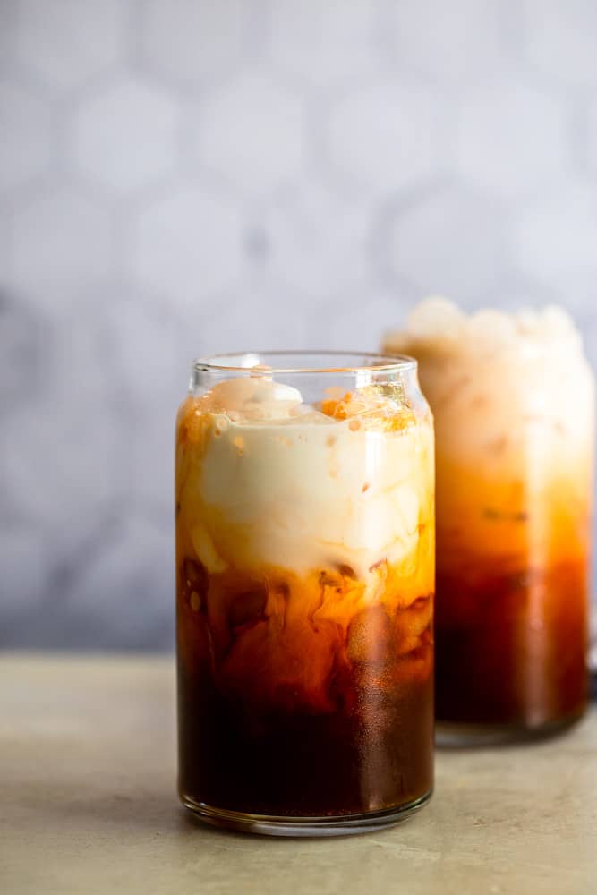 Glass of thai iced tea with cream on top, not mixed together.