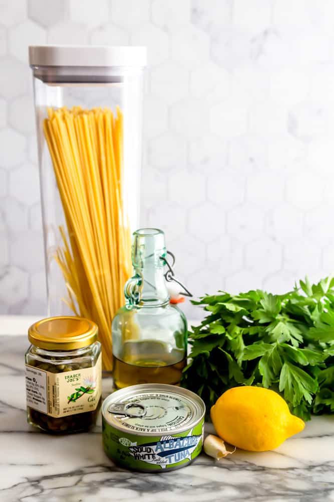 Ingredients for tuna pasta - spaghetti, capers, olive oil, parsley, canned albacore tuna, lemon, garlic.