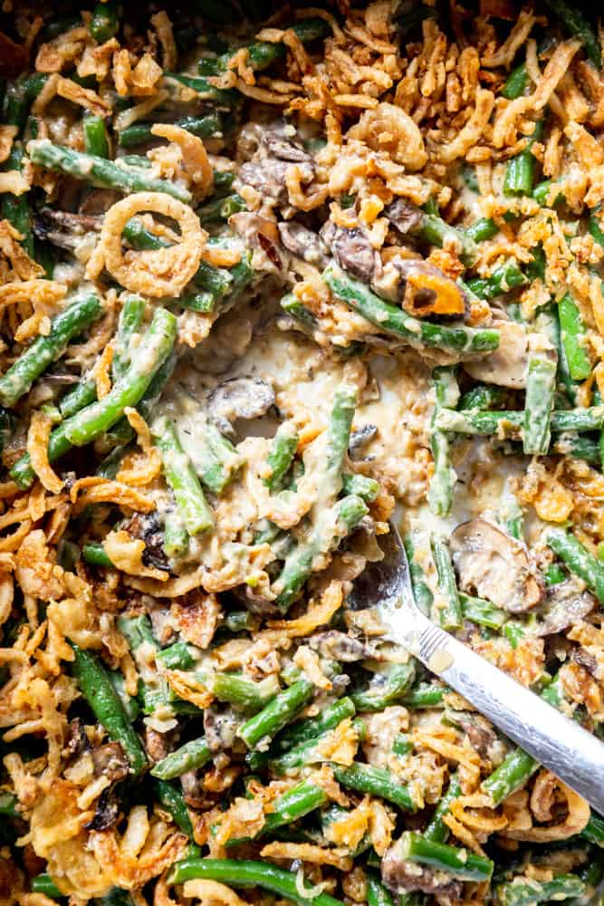 Close up of fresh green bean casserole with mushrooms, green beans, French fried onions, and a creamy sauce.