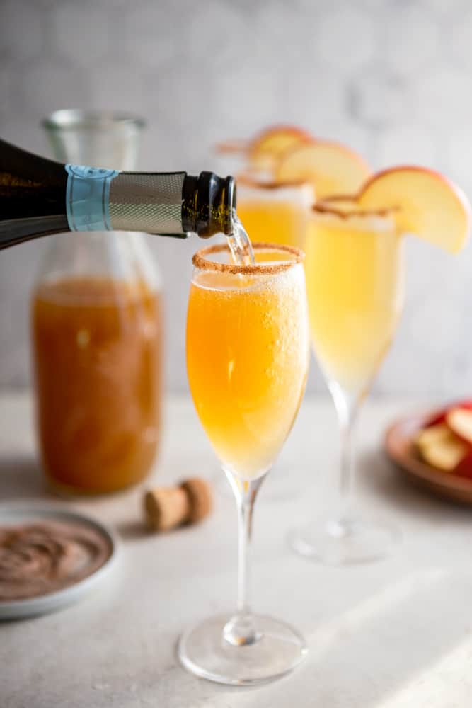 Prosecco pouring into a champagne glass with apple cider.