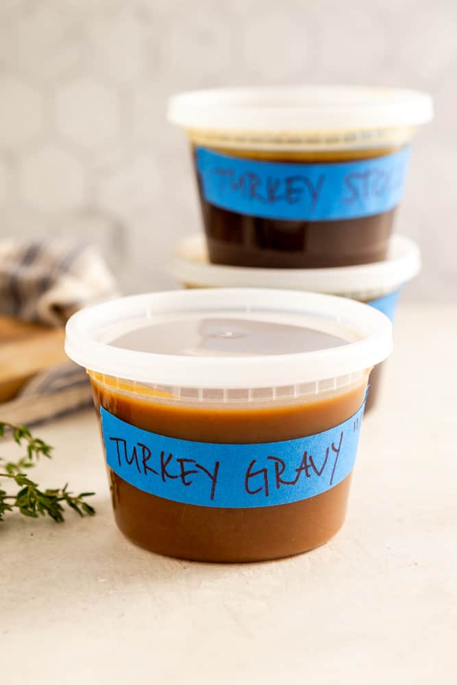 Food storage container marked with blue tape that says "Turkey Gravy".