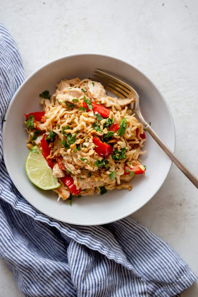 Peanut Ramen Noodles with leftover turkey and bell peppers in a white bowl.