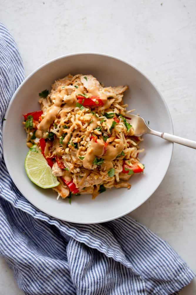 Peanut Ramen with leftover turkey in a white bowl, drizzled with extra peanut sauce.