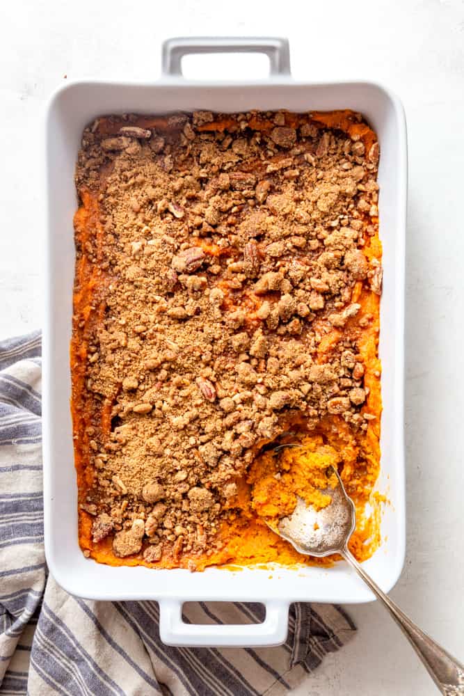 Sweet potato casserole with pecan streusel topping in a white casserole dish.