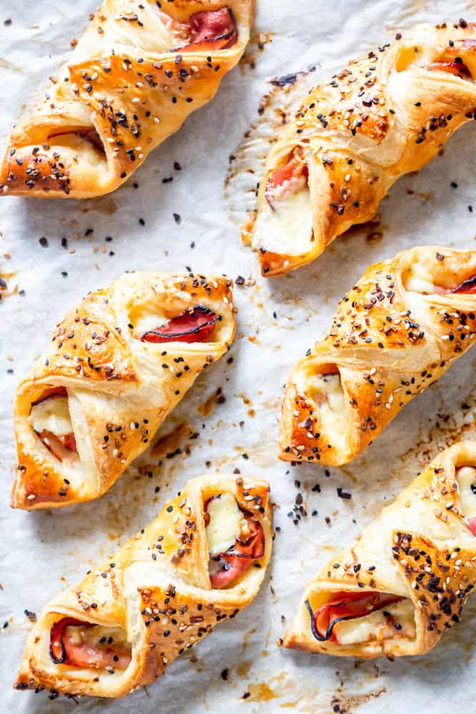 Ham and Cheese puff pastry bundle on a sheet of parchment paper