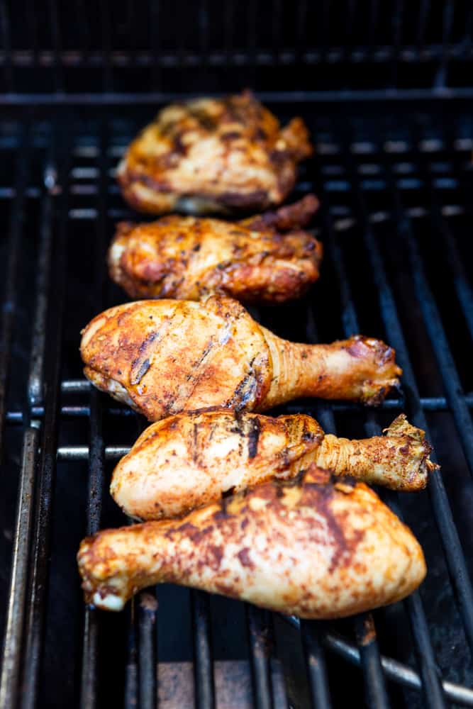 Chicken drumsticks and thighs on a grill, with grillmarks