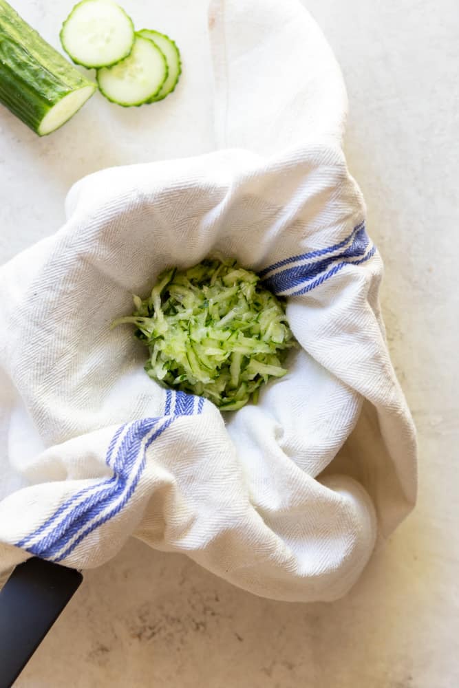grated cucumber draining on a kitchen towel