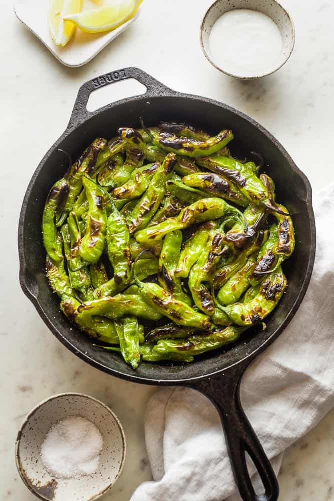 Blistered Shishito Peppers in a cast iron skillet