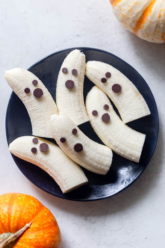 Boo-nanas.  Bananas that look like ghosts. Bananas peeled and cut in half, with mini chocolate chips for eyes and regular sized chocolate chips for mouths. 