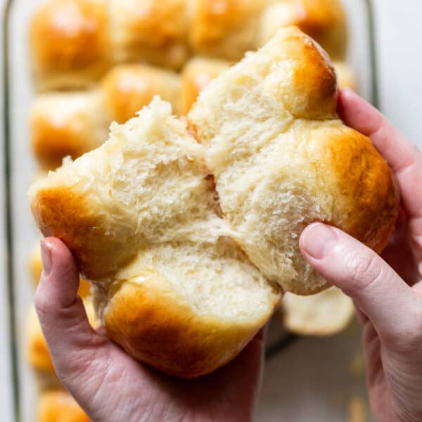 Soft and fluffy dinner rolls being pulled apart.