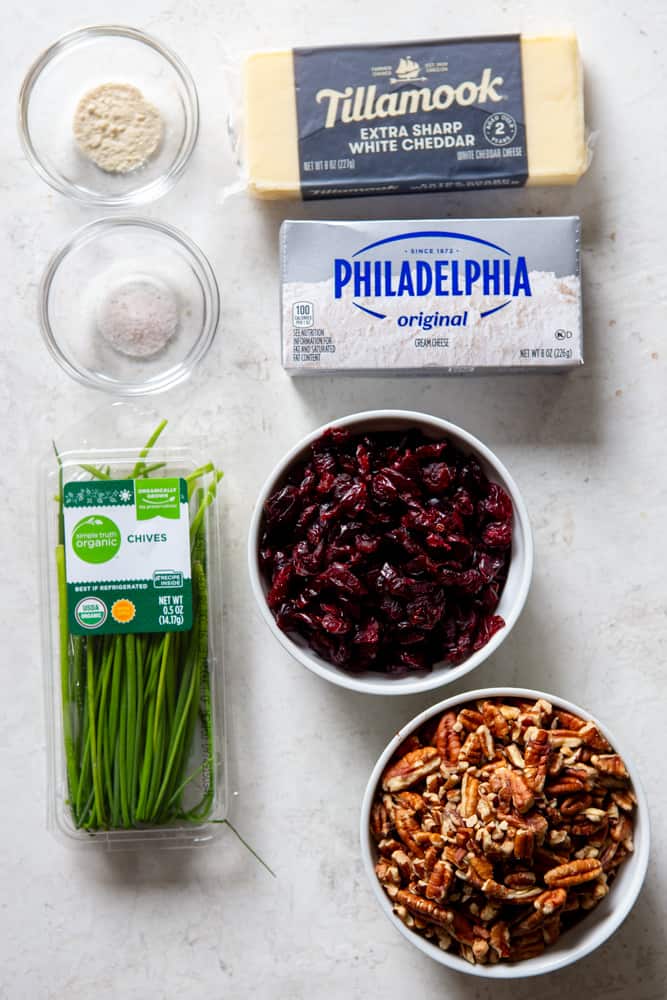 Ingredients for cranberry pecan cheese ball: cream cheese, sharp white cheddar cheese, chives, dried cranberries, chopped pecans, sea salt, garlic powder. 