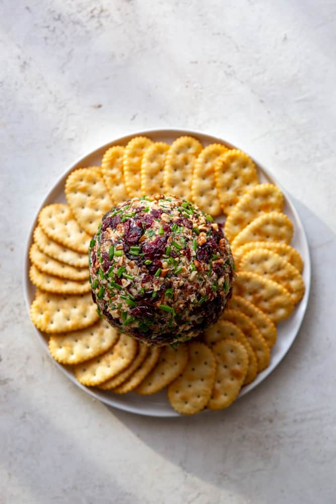 Cranberry Pecan Cheese Ball on a place with crackers.