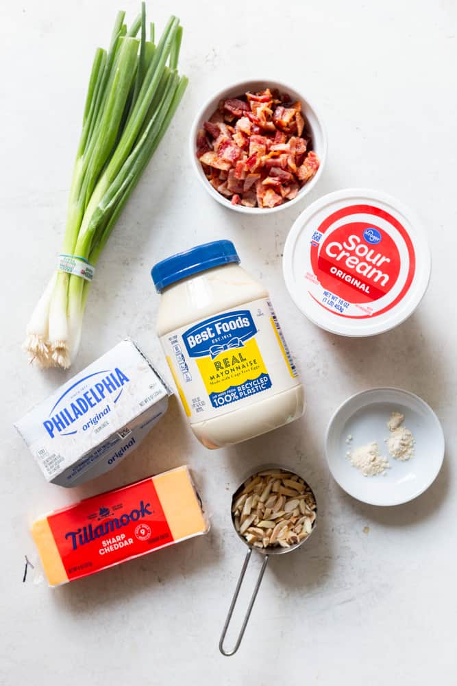 Ingredients for million dollar dip: Green onions, chopped cooked bacon, sour cream, mayonnaise, cream cheese, sharp cheddar cheese, slivered almonds, garlic powder, onion powder.  