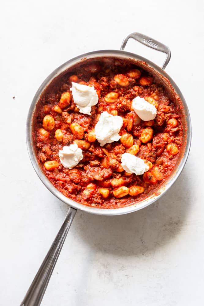 One Pot Gnocchi with Sausage in a skillet dolloped with ricotta