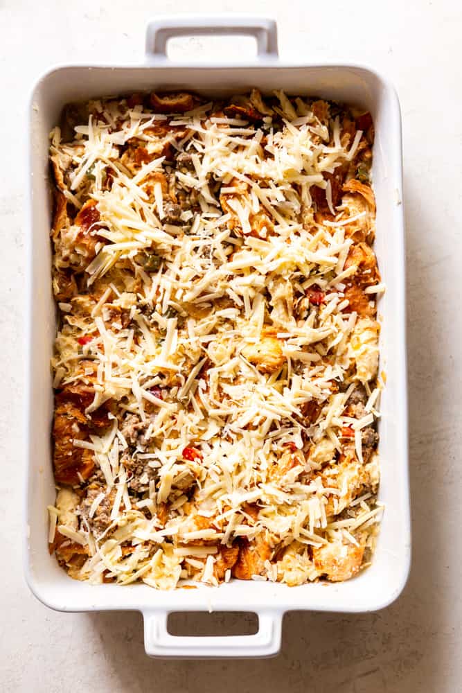 Croissant Casserole in a baking dish topped with cheese before being baked. 