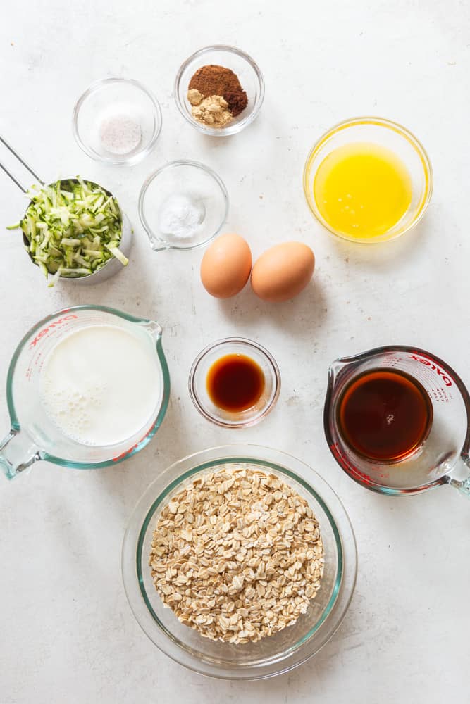 Ingredients for Zucchini Baked Oatmeal: Rolled Oats, pure maple syrup, vanilla extract, milk 2 eggs, melted butter, grated zucchini, spices, salt and baking powder.
