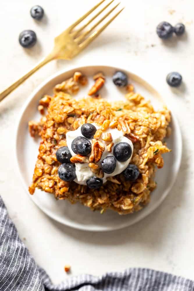 A slice of Zucchini Baked Oatmeal topped with yogurt, blueberries and pecans.