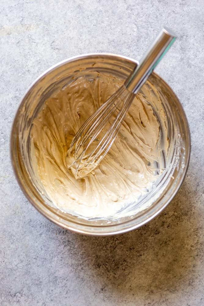 Tahini sauce after being whisked in a stainless steel bowl. 