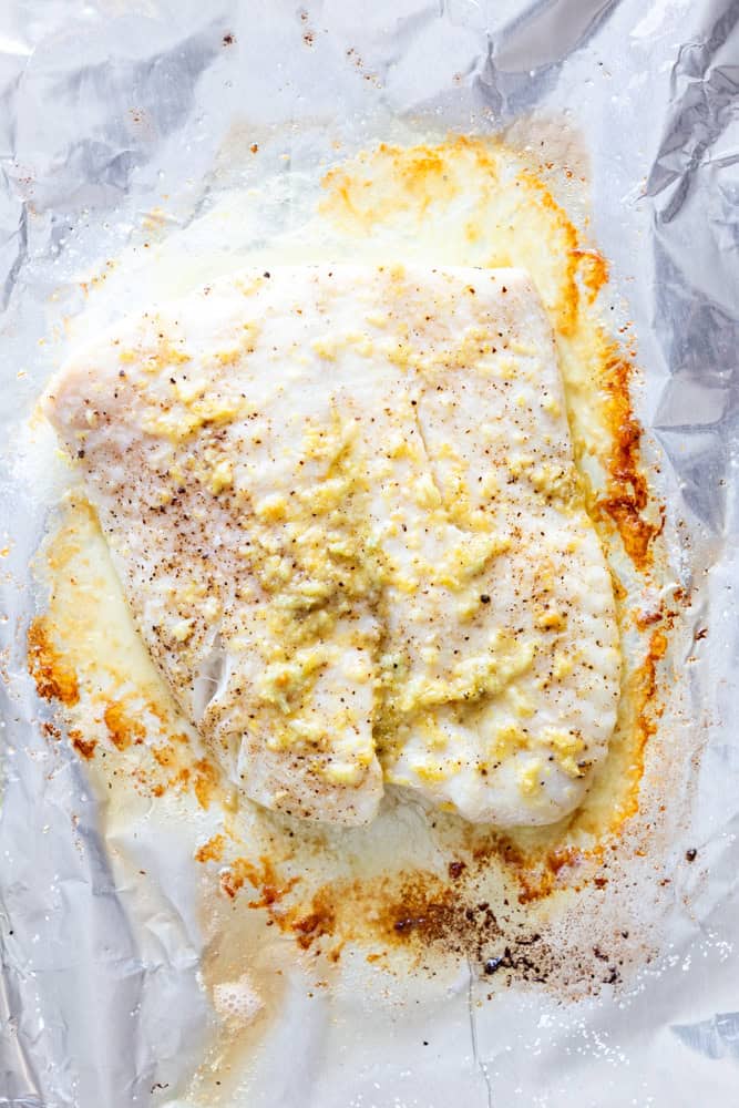 Halibut filet with Garlic Butter after being baked on a foil lined baking sheet.