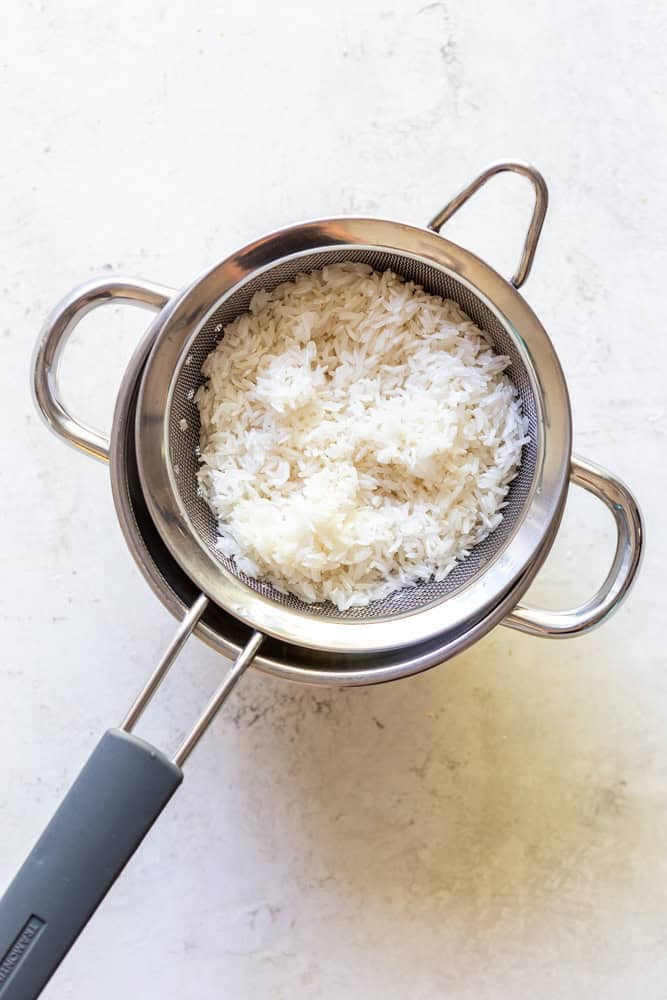 rinsed rice in a mesh strainer