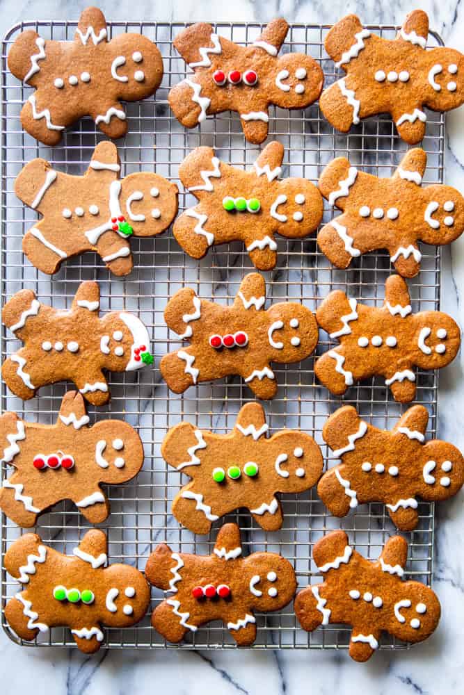 Decorated gingerbread people cookies on a cooling rack.