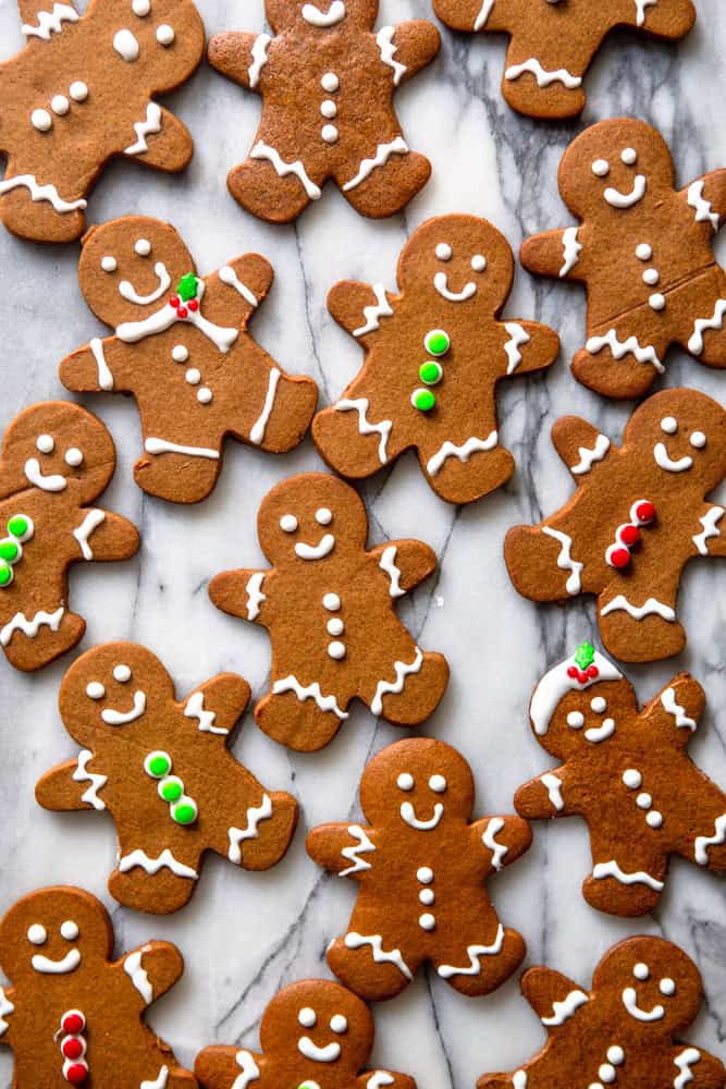 Decorated gingerbread people cookies on a marble slab.